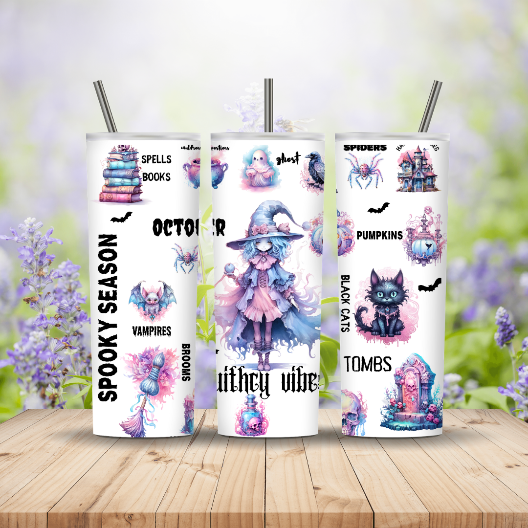 Three Halloween-themed tumblers with designs and text on a wooden surface with a blurred floral background.