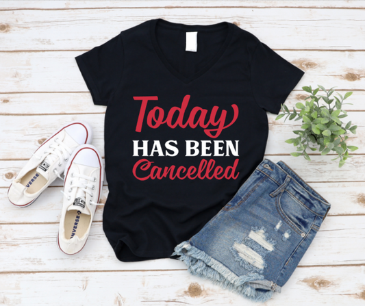 Black t-shirt with 'Today has been cancelled' text, paired with white sneakers and denim shorts on a wooden surface. www.missmafia.com