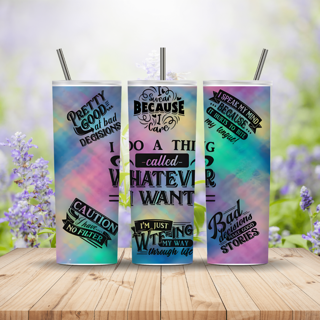 Three colorful tumblers with motivational quotes on a wooden surface with a floral background.