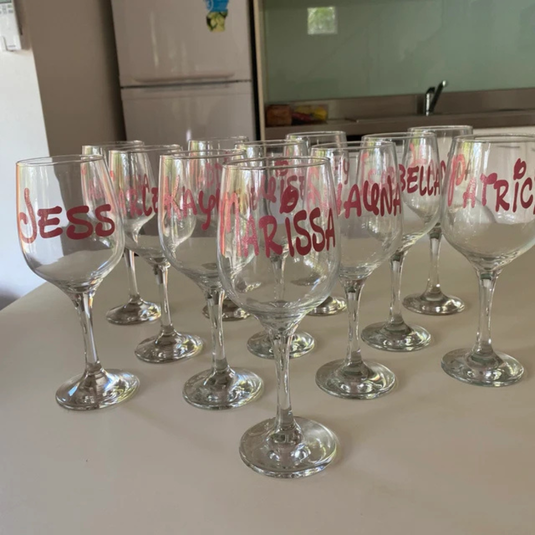 Set of wine glasses with names written on them in a kitchen setting