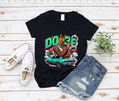 Black t-shirt with a graphic design of a dog and car, paired with white sneakers and denim shorts on a wooden surface.
