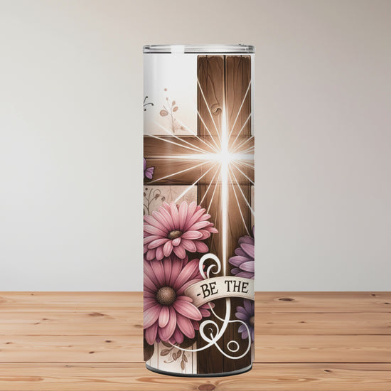 Christian tumbler with wooden cross, glowing light, pink and purple flowers, butterflies, and ‘Be The Light’ message