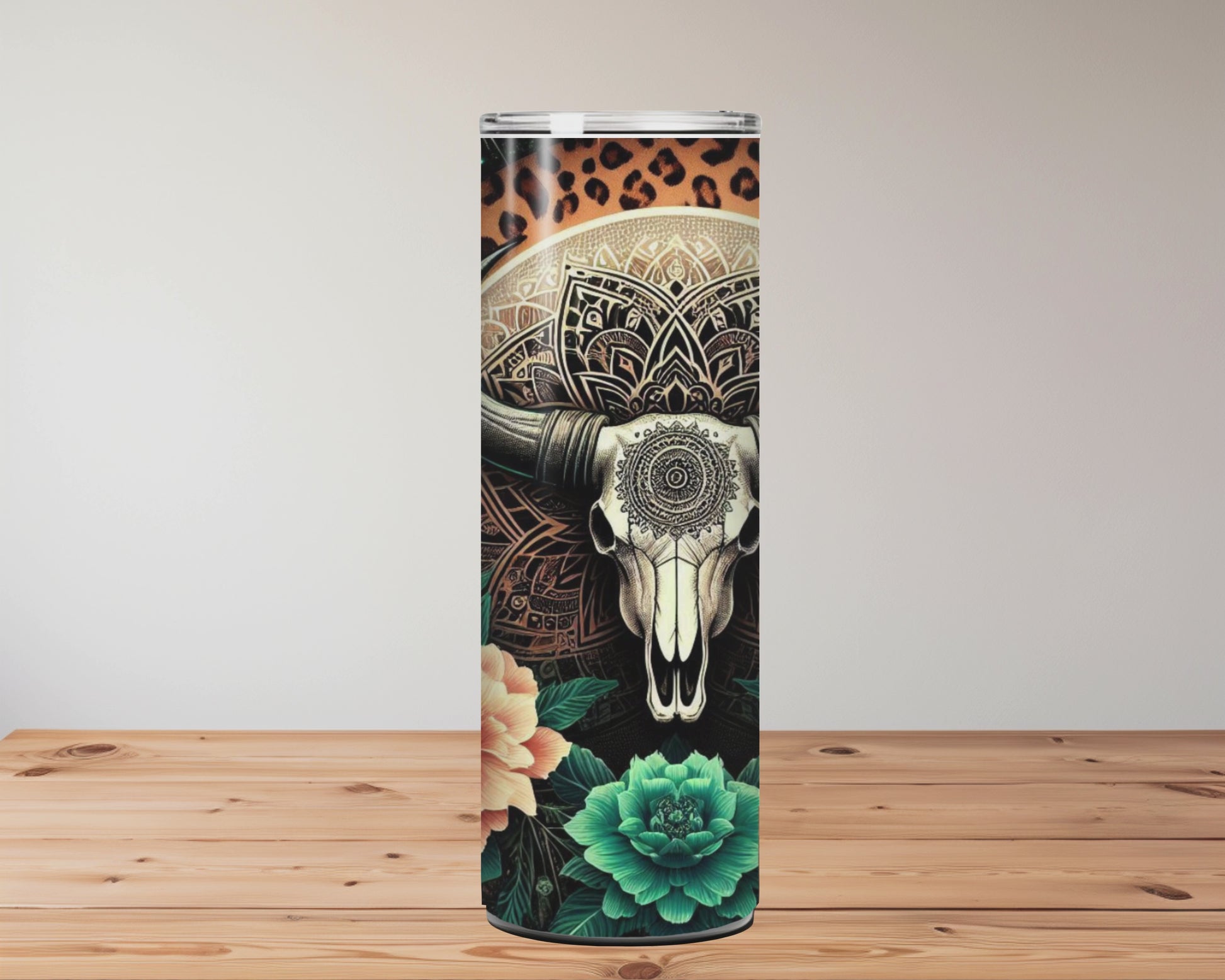 20oz stainless steel tumbler with a boho-western design featuring a mandala bull skull, surrounded by teal succulents, orange florals, feathers, and a starry leopard-print background. Miss Mafia