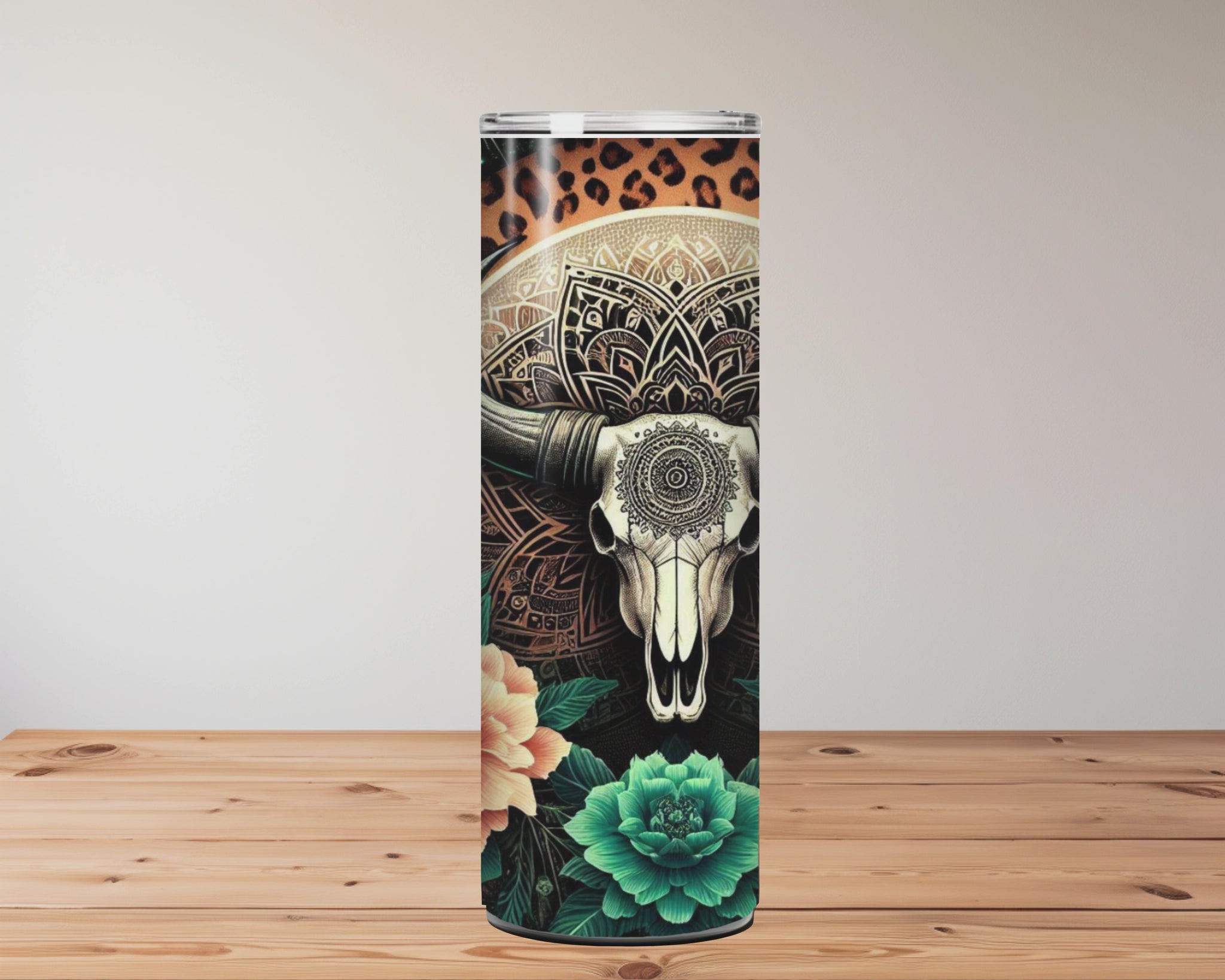 20oz stainless steel tumbler with a boho-western design featuring a mandala bull skull, surrounded by teal succulents, orange florals, feathers, and a starry leopard-print background. Miss Mafia