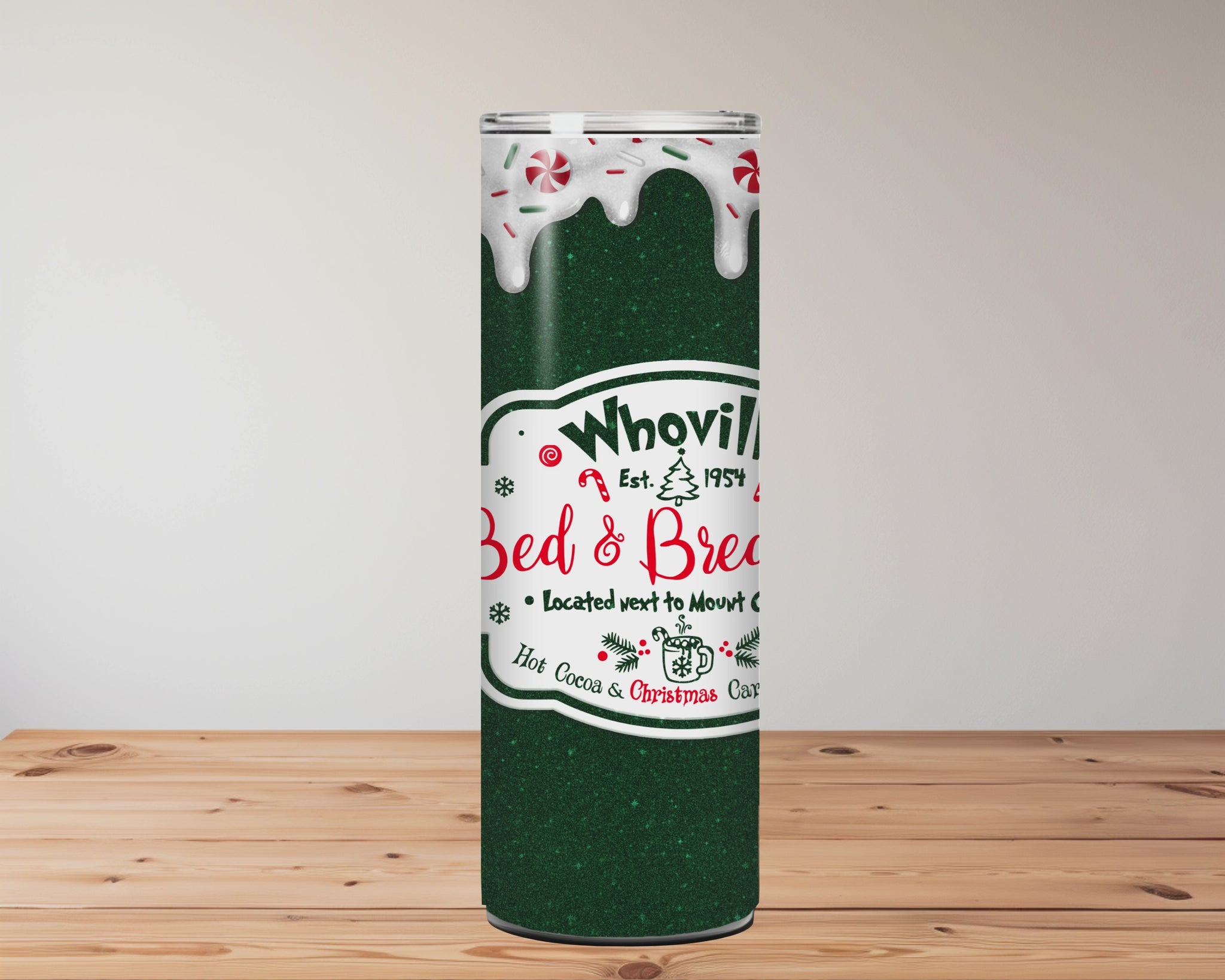green tumbler with 'Whoville Bed & Breakfast' logo on a wooden surface