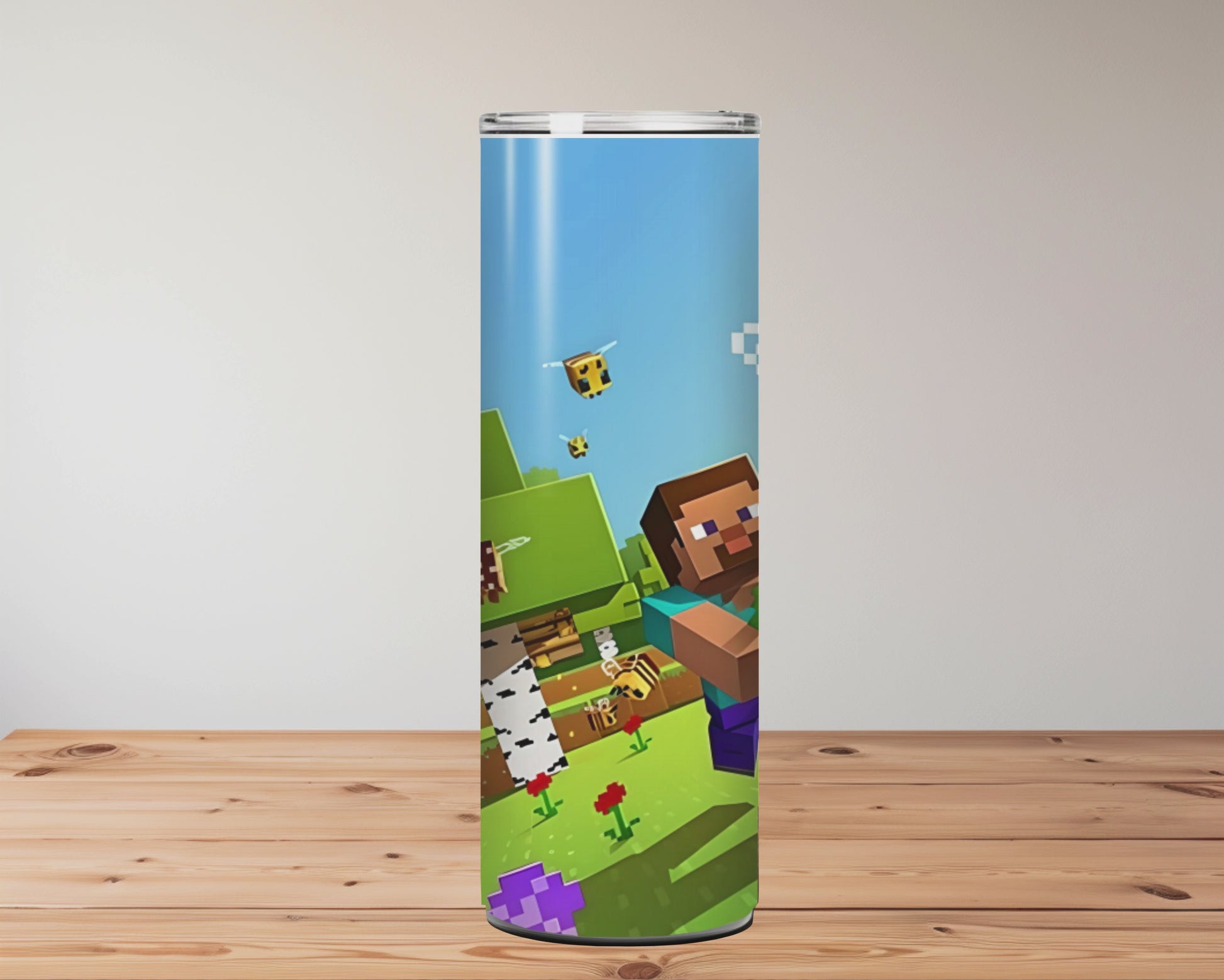 Three colourful tumblers with Minecraft-themed designs on a wooden surface. Miss Mafia